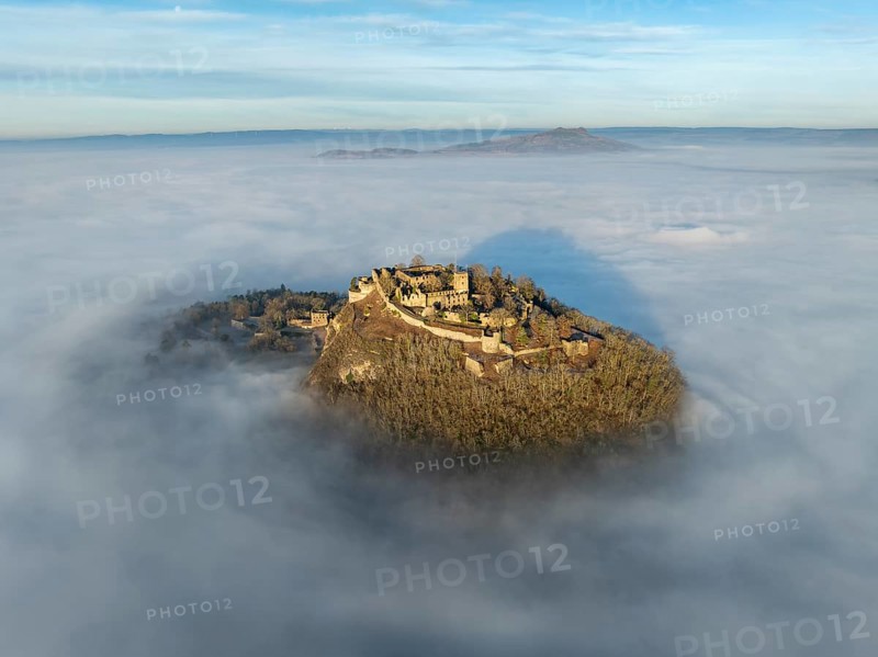 Aerial view of the Hegau volcano Hohentwiel with the upper fortress ruins illuminated by the rising sun, which rises out of the fog during an inversion weather situation, on the horizon the Hohenstoffeln, district of Constance, Baden-Württemberg, Germany, Europe