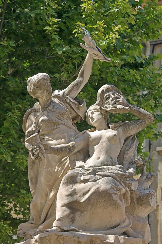 Fountain with sculptures, two woman, mask, high, hold, arm, up, robe, theatre square, Orange, Vaucluse, Provence, France, Europe