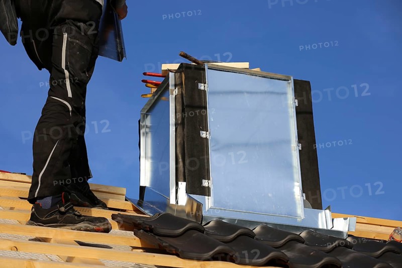 Roofer works on the chimney cladding