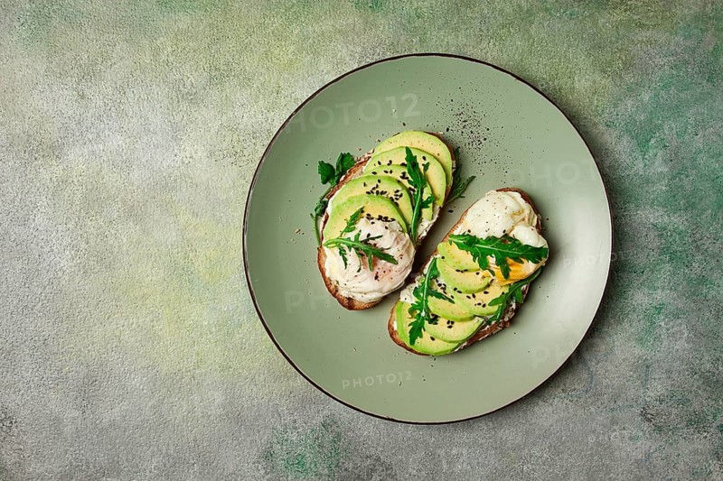 Sandwich with cream cheese, sliced avocado and boiled egg, arugula, on grainy bread, homemade, breakfast, no people