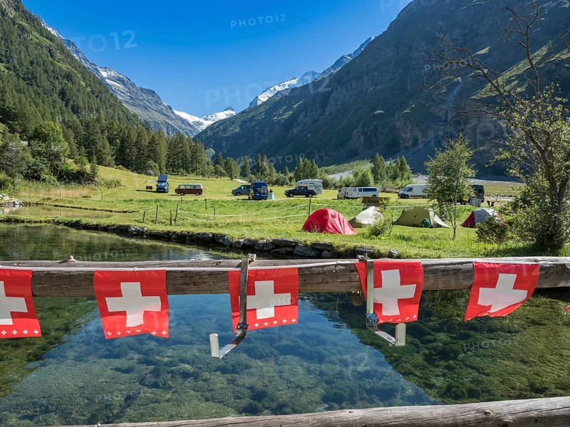 Tents and camper vans on a small campsite, village Zinal, mountain range in the back, Val d'Anniviers, Switzerland, Europe