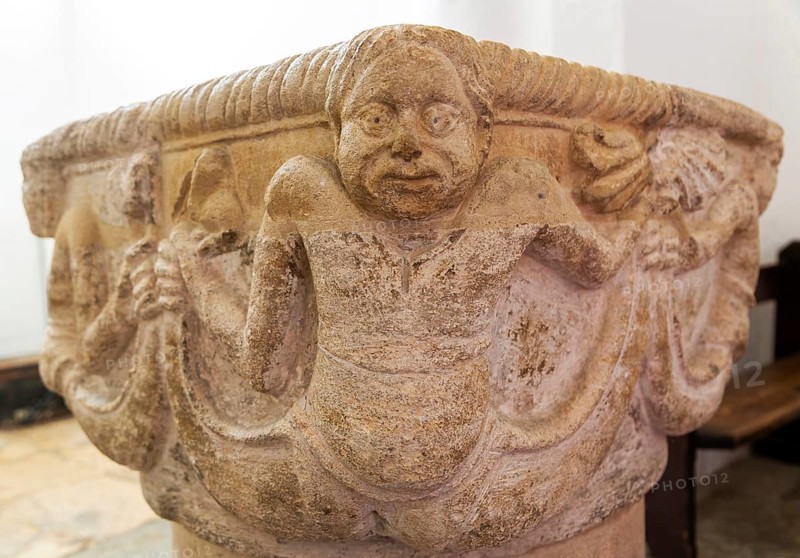 Carved stonework Merman figure baptismal font, church of Saint Peter, Cambridge, Cambridgeshire, England, UK, 12th century font