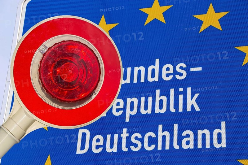 Symbolic image of the asylum debate: trowel in front of a border sign of the Federal Republic of Germany (Composing)