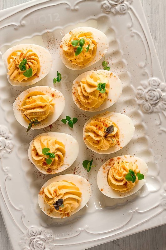Boiled eggs stuffed with yolk with mayonnaise, on a white plate, selective focus, blurry, close-up, no people