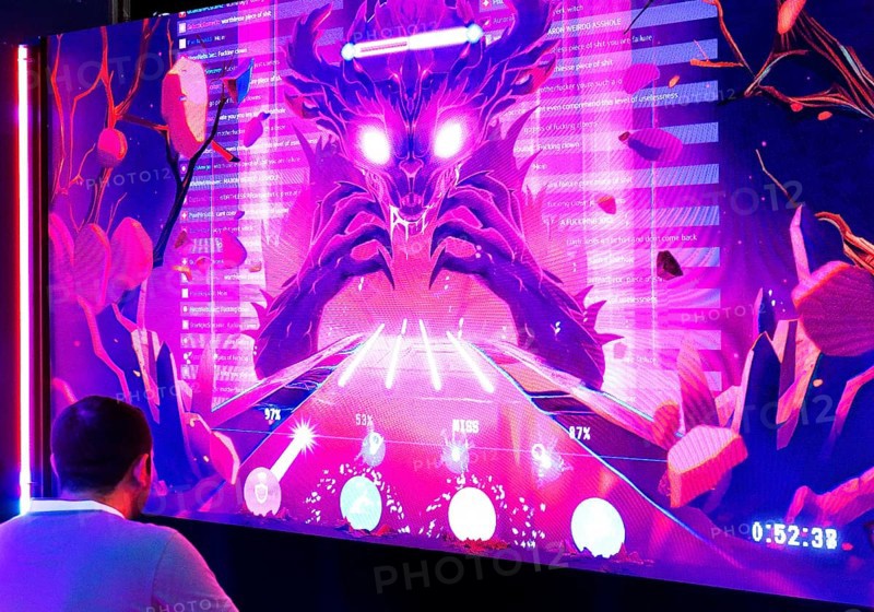 Visitors in front of a large screen with the Toxic Monster, which lives from hate on the Internet, Gamescom trade fair, Cologne, Germany, Europe