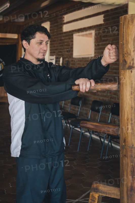 Male martial arts practitioner demonstrating the Lap Sao and Lap-dá technique, which emphasizes the ability to control the opponent through strategic grappling combined with a punch, showcasing the synergy between attack and defense characteristic of Wing Chun