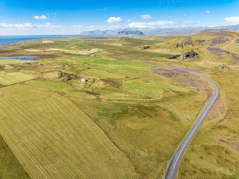 Aerial view of road leading to Cape Dyrholaey, lava formations and meadows, southern coast, Iceland, Europe