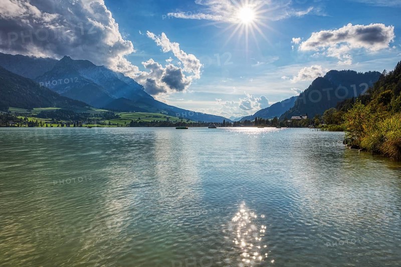 Picturesque mountain landscape with a calm lake under a bright sun and blue sky, Walchsee