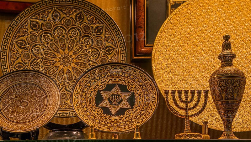 Gold-decorated decorative plates with intricate patterns and symbols, including a menorah and Star of David, presented on stands, Toledo, Castilla-La Mancha, Spain, Europe