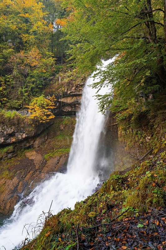 A waterfall cascades down in a wooded area with colourful autumn leaves, Lake Brienz, Giessbach Waterfall, Switzerland, Europe