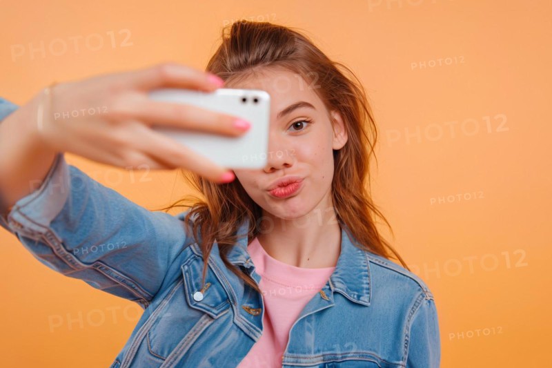 Young teenage girl taking selfie in front of studio background. KI generiert, generiert, AI generated