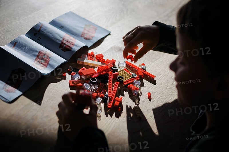 Symbolic photo on the subject of Lego. A six-year-old boy sits at a table and assembles a construction kit made of Lego bricks. Berlin, 08.05.2024