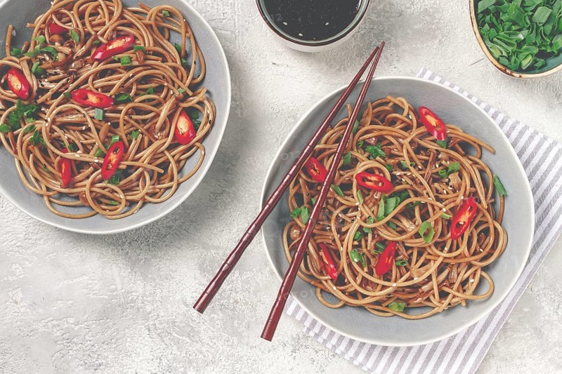 Udon noodles, with shimeji mushrooms, vegetables, in sauce, with sesame seeds, green onions, Asian vegetarian food, horizontal, without people