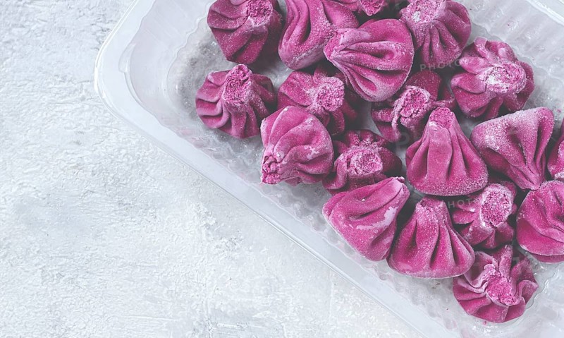 Freshly frozen beetroot khinkali, in a container, top view, no people