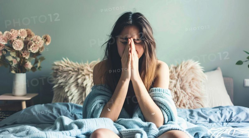 A woman lying in bed with a tissue in her hand, looking very sick with high temperature and fever, AI generated