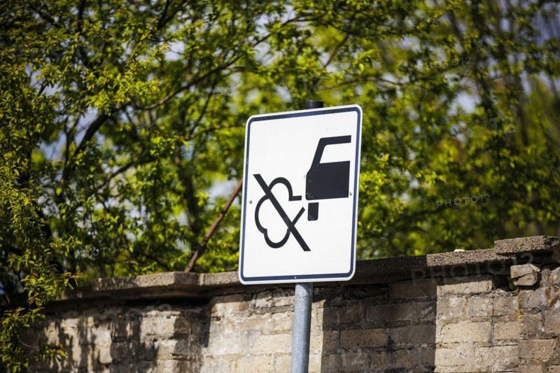 Symbolic photo on the subject of air pollution. A traffic sign with a crossed-out exhaust cloud warns road users not to leave their engines running. Oranienburg, 23.04.2024