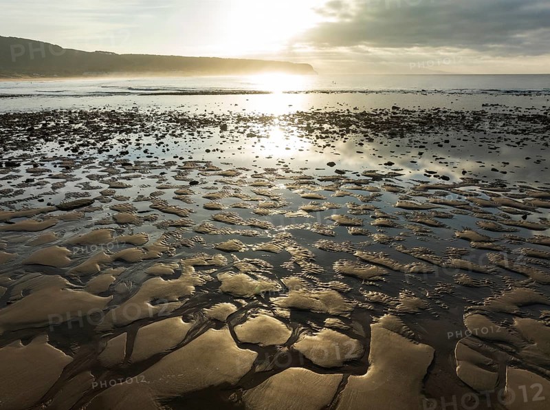 Sunrise at low tide at the shore of the Atlantic Ocean near Cape Trafalgar. Aerial view. Drone shot. Costa de la Luz, Cádiz province, Andalusia, Spain, Europe