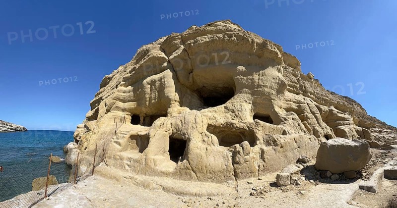 Panoramic view of former Roman necropolis with sandstone caves carved into sandstone Cave tombs Grottoes in rocks on the north side of Matala Bay, in the 60s and 70s hippie caves Caves for dropouts and hippies today excursion destination on the south coast of Crete island, Matala, Crete, Greece, Europe