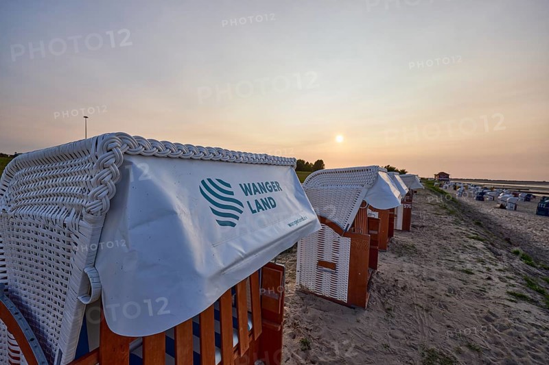 Beach chair with the inscription Wangerland in the backlight of the sunset on the beach of the district Hooksiel, Wangerland, district Friesland, Lower Saxony, Germany, Europe