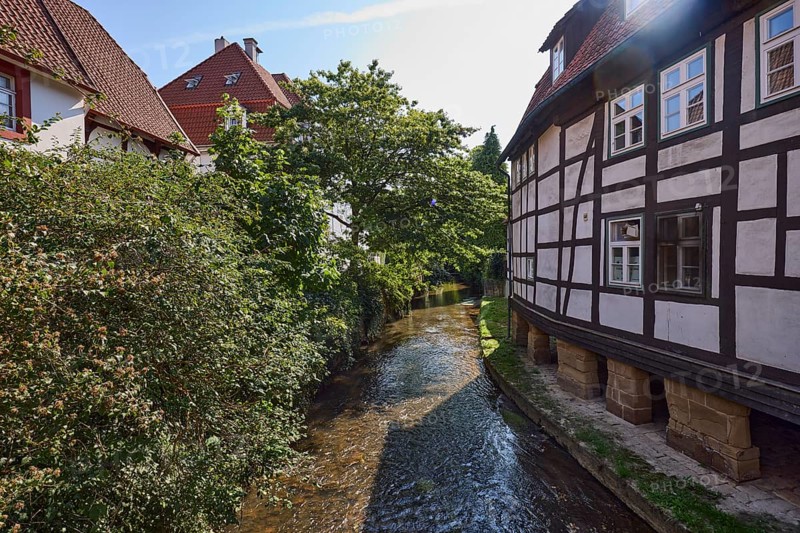 Historic half-timbered houses on the Salze river backlit in the town centre of Bad Salzuflen, Lippe district, North Rhine-Westphalia, Germany, Europe