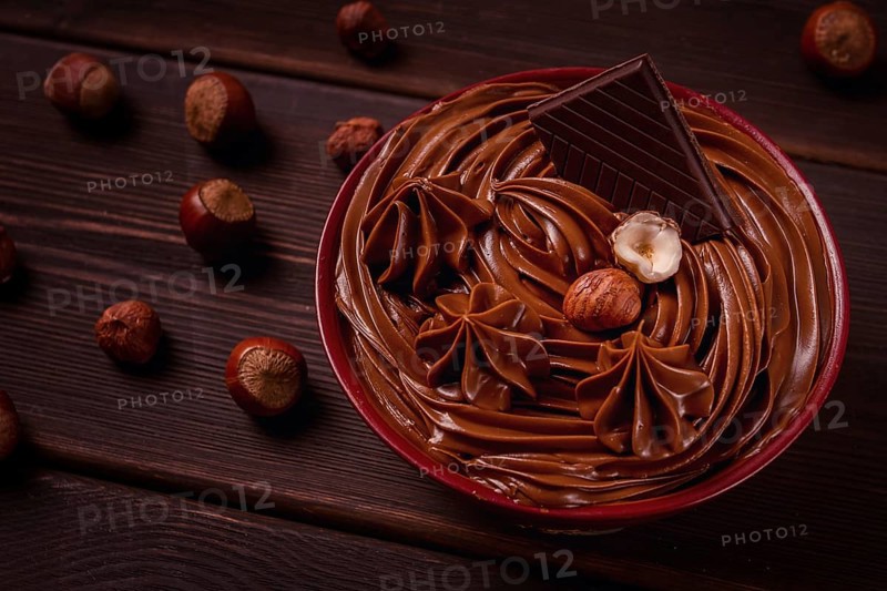 Chocolate nut paste, mousse, pasta, in a cup, on a wooden table, top view, selective focus, no people