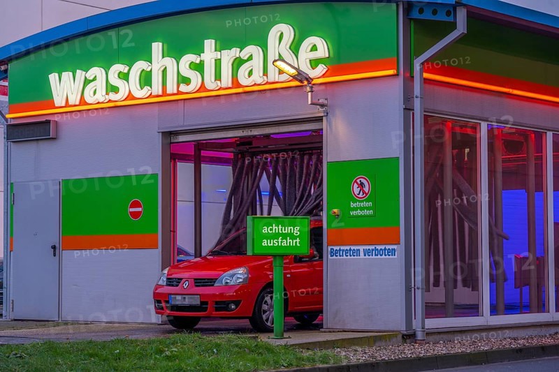 Car in an automatic car wash, car wash tunnel, vehicle drying after washing with warm compressed air and drying cloths