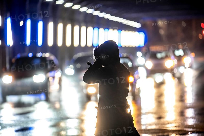 Illuminated subway at the main railway station, pedestrians at a pedestrian crossing, rainy weather, city centre, in the evening, Essen, North Rhine-Westphalia, Germany, Europe