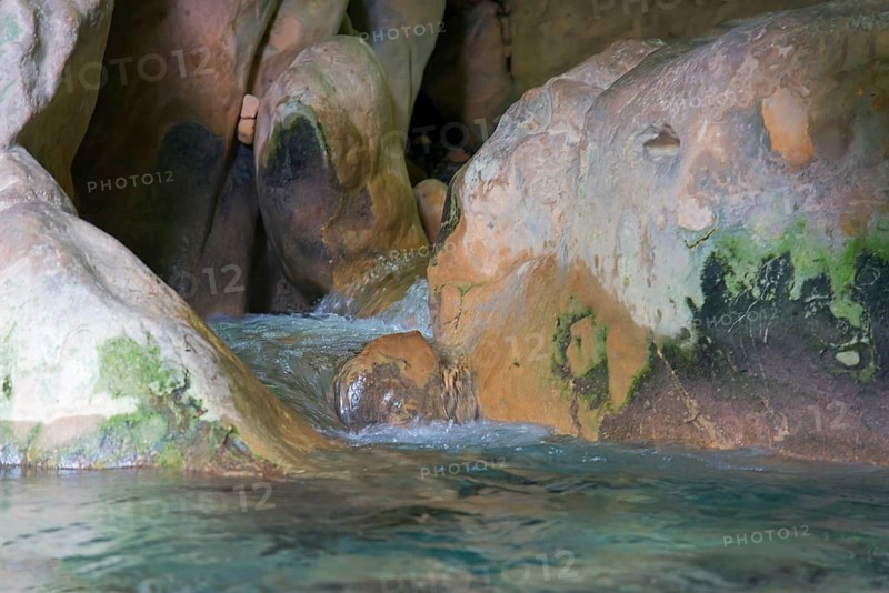 Water flows through a rocky cave with moss-covered stones, a peaceful and natural environment, Gruta Rio Cuadros, near Bedmar y Garcíez, Bedmar y Garciez, Sierra Mágina Natural Park, Jaén province, Jaen, Andalusia, Spain, Europe