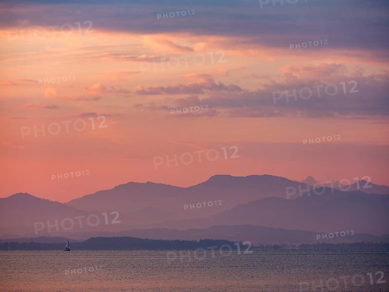 Small sailing boat on the Chiemsee in the morning light, behind the Chiemgau Alps, Chiemgau, Upper Bavaria, Bavaria, Germany, Europe