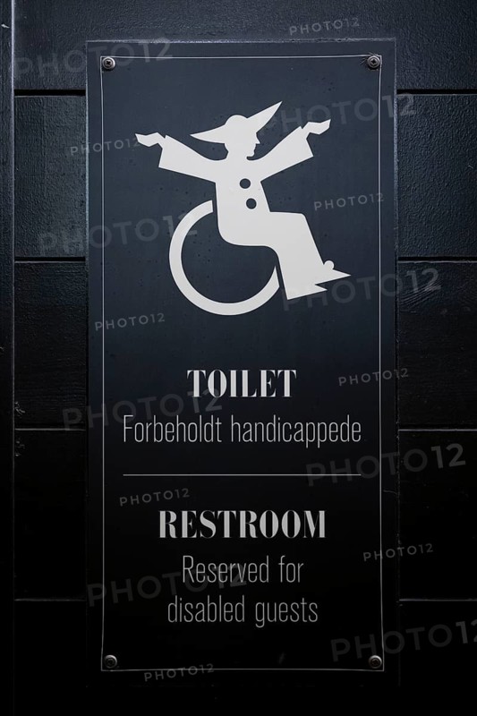 Sign for disabled toilet with wheelchair symbol on black background, Tivoli Amusement and Recreation Park, Copenhagen, Denmark, Europe
