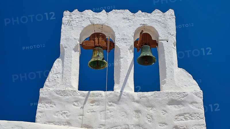 White bell tower with two bells in front of a bright blue sky, Chora, Old Town, Patmos, Dodecanese, Greek Islands, Greece, Europe