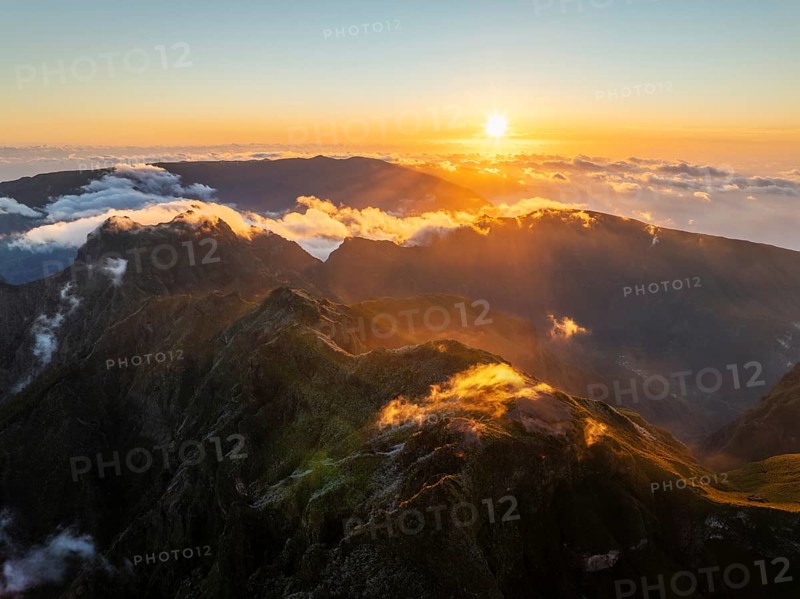 Aerial drone view of mountains over clouds near Pico Ruivo on sunset. Madeira island, Portugal, Europe
