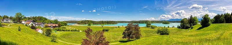 A panorama of a village on a lake with surrounding meadows and mountains, Osterseen