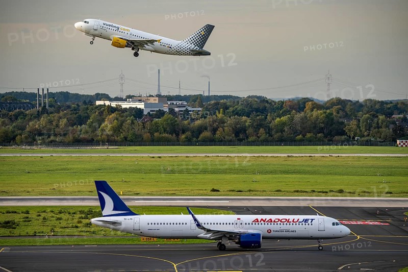 Düsseldorf Airport, Vueling.com Airbus on take-off, Anadolujet Airbus on the taxiway for take-off