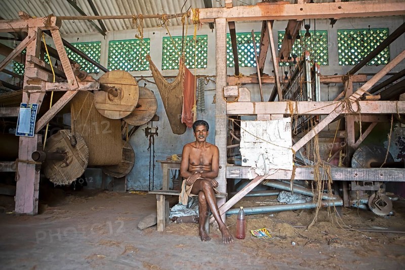 Indian worker, 68 years old, sitting in the weaving mill of the Labourers Coir Mats and Mattings Cooperation, coir mat production, Muhamma, Alappuzha, Kerala, India, Asia