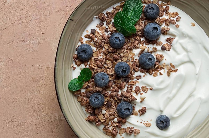 Yogurt with chocolate muesli, with berries, blueberries, breakfast, close-up, fork on top, no people