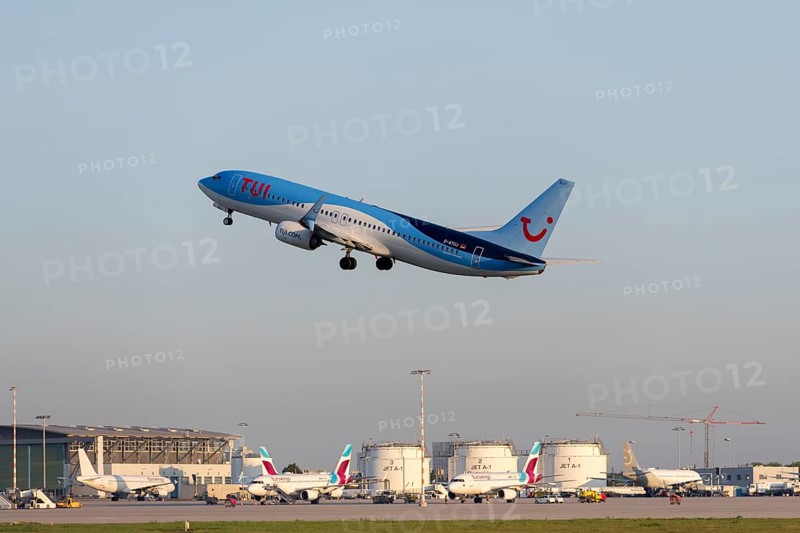A TUI plane takes off from the airport, the sky is clear and blue, other planes and airport buildings in the background, symbolising the beginning of a journey, Stuttgart, Baden-Württemberg, Germany, Europe