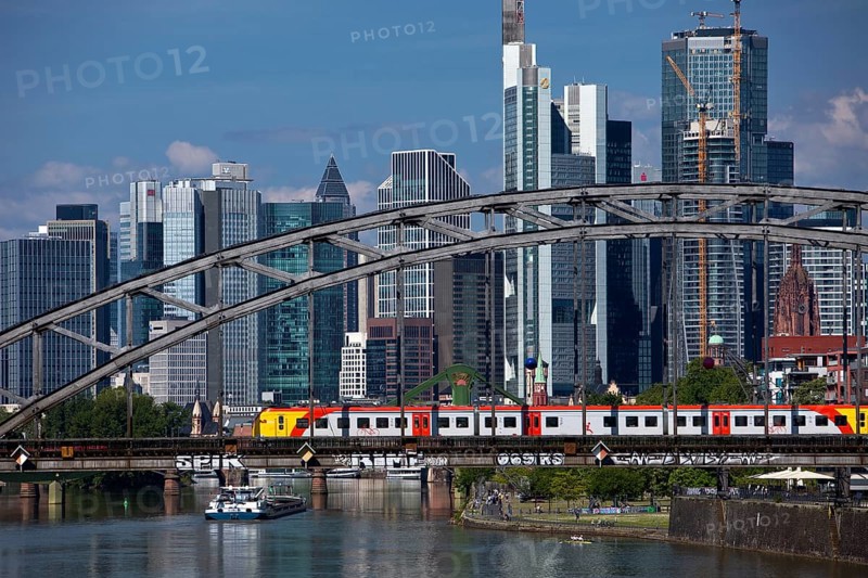 Main with regional railway on the Deutschherrnbrücke and a cargo ship in front of the skyline of Frankfurt am Main, Hesse, Germany, Europe