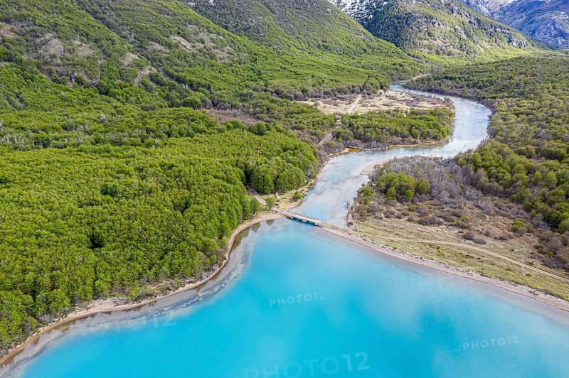 Aerial view of lake Lago Jeinimeni, river flowing out of the lake, glacial blue water in contrast to green forest, Jeinimeni National Park, Patagonia, Chile, South America