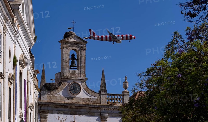 Condor holiday plane, aeroplane, flies low over city archway, stork nests, nest, storks nesting on archway, Arco da Vila, old town, Faro, Algarve, Portugal, Europe