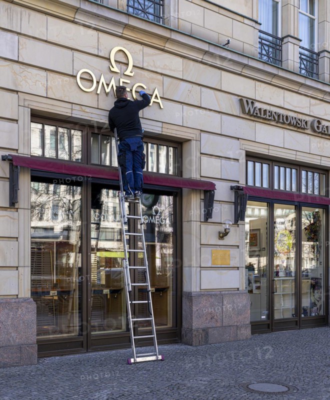 Omega, craftsman cleans the company logo, Unter den Linden, Berlin, Germany, Europe
