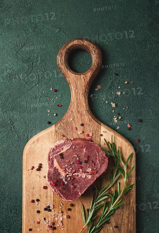 Fresh, raw rib eye steak, on a chopping board, top view, no people