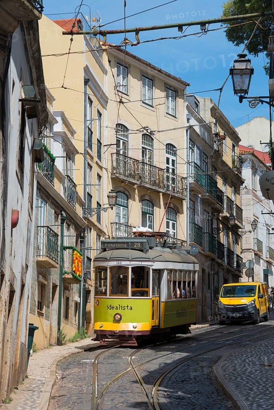 A yellow-green tram winds its way along a narrow, steep alley surrounded by old buildings, Tram, Line 28, Carros eléctricos de Lisboa, Eléctricos de Lisboa, Old Town, Lisbon, Portugal, Europe