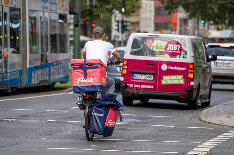Flink delivery service courier cyclist and bottle delivery vehicle, in Düsseldorf, North Rhine-Westphalia, Germany, Europe