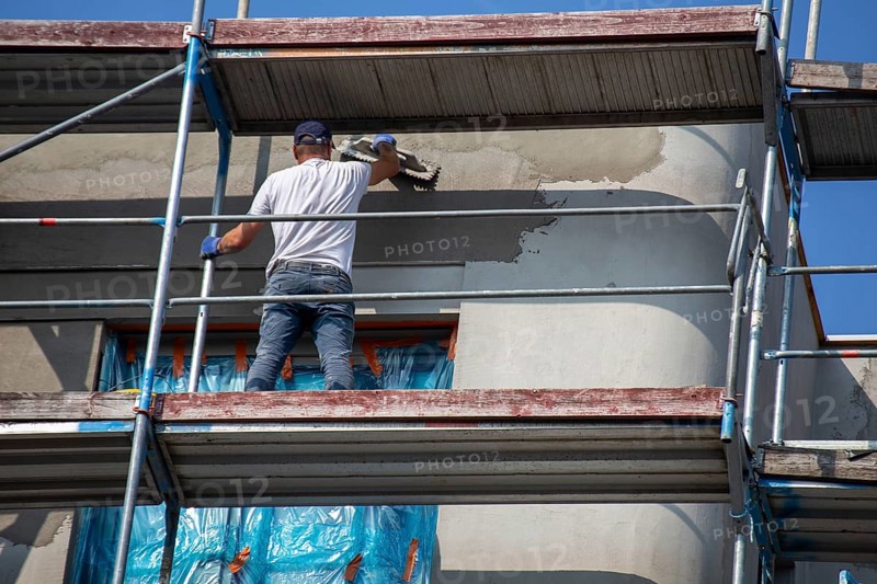 Painter painting the façade of a new apartment building