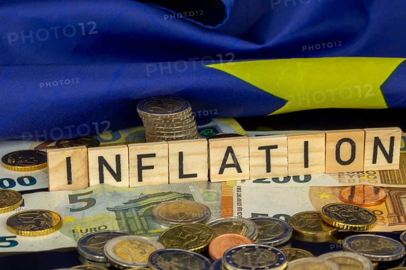 Symbolic image of inflation (in the euro area) : The word INFLATION in letter cubes on euro coins and banknotes