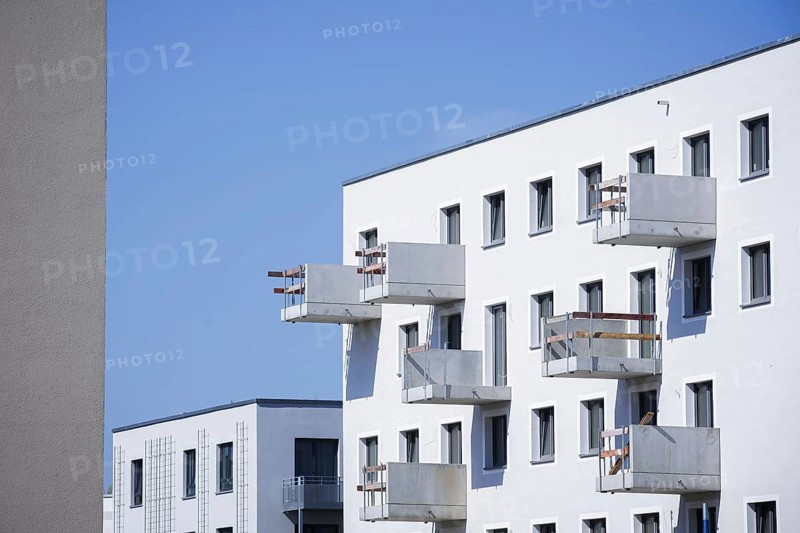 Symbolic photo on the subject of new housing construction. Buckower Felder neighbourhood on the southern outskirts of Berlin. Around 900 flats are being built on the 16-hectare site. A parasol stands on the balcony of a new-build flat that has already been occupied. View of balconies under construction. Berlin, 29.08.2024