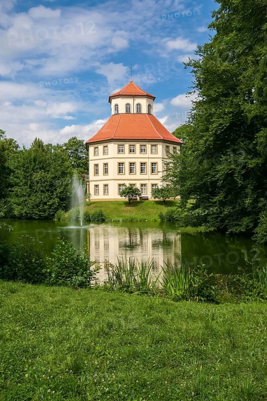 Oppenweiler moated castle, built in the 18th century, classicist style, castle complex in unequal-sided octagon, today town hall, architecture, tent roof with pavilion top, windows, lake, castle lake, water features, island, park, garden designer Friedrich Ludwig von Sckell, meadow, lawn, trees, bushes, shrubs, cloudy sky, Oppenweiler, Rems-Murr district, Baden-Württemberg, Germany, Europe