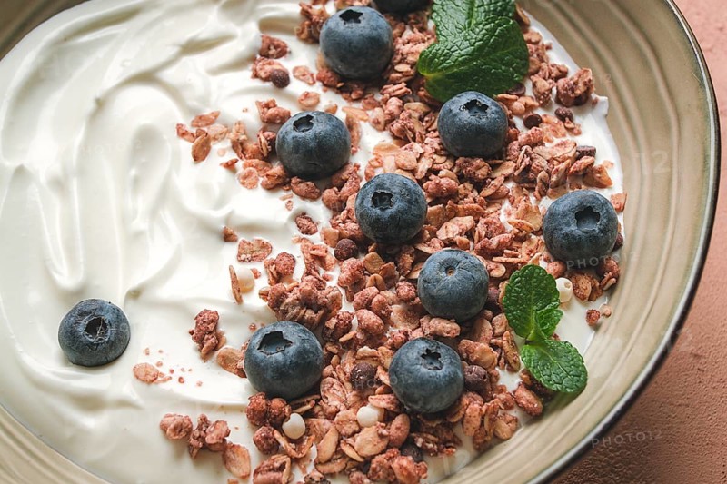 Yogurt with chocolate muesli, with berries, blueberries, breakfast, close-up, fork on top, no people