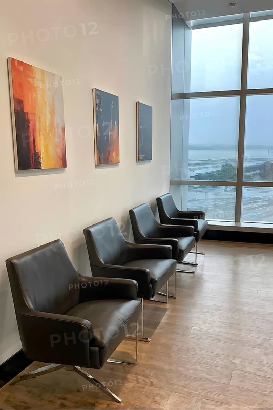 Minimalist styled waiting room with an ordered row of chairs lined up, AI generated